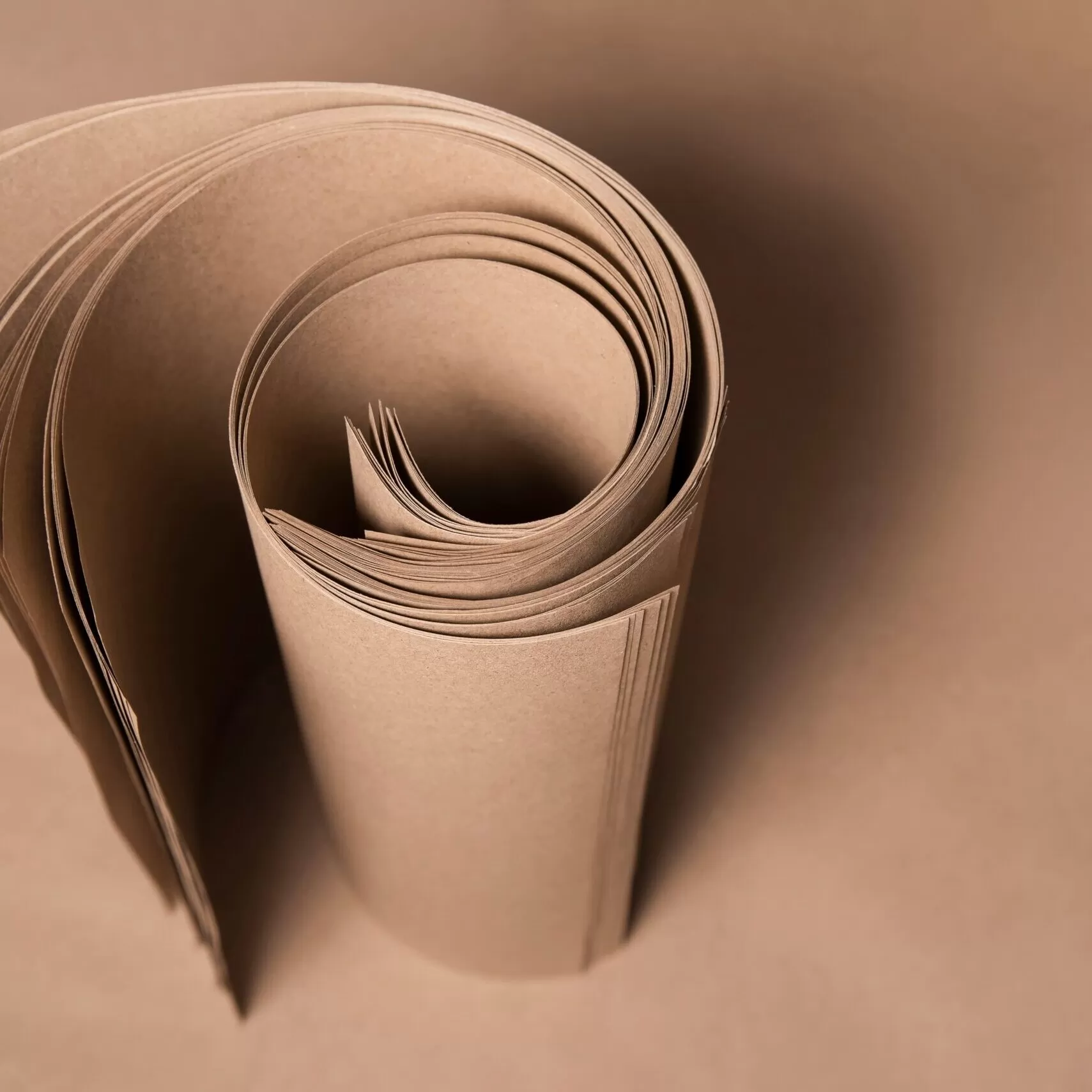Rolo de papel Kraft sendo usado para embalar um presente